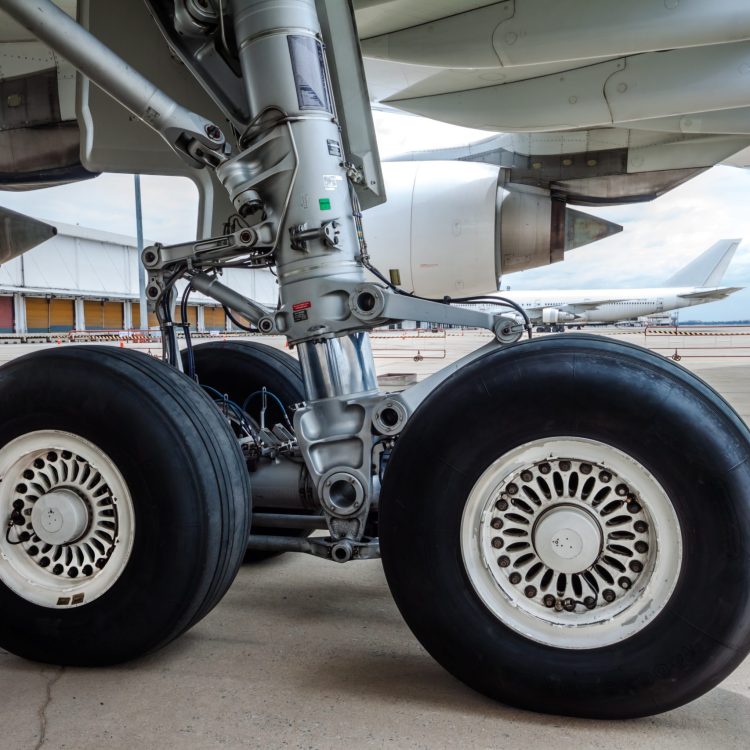 close up of airplane wheel parked at the airport